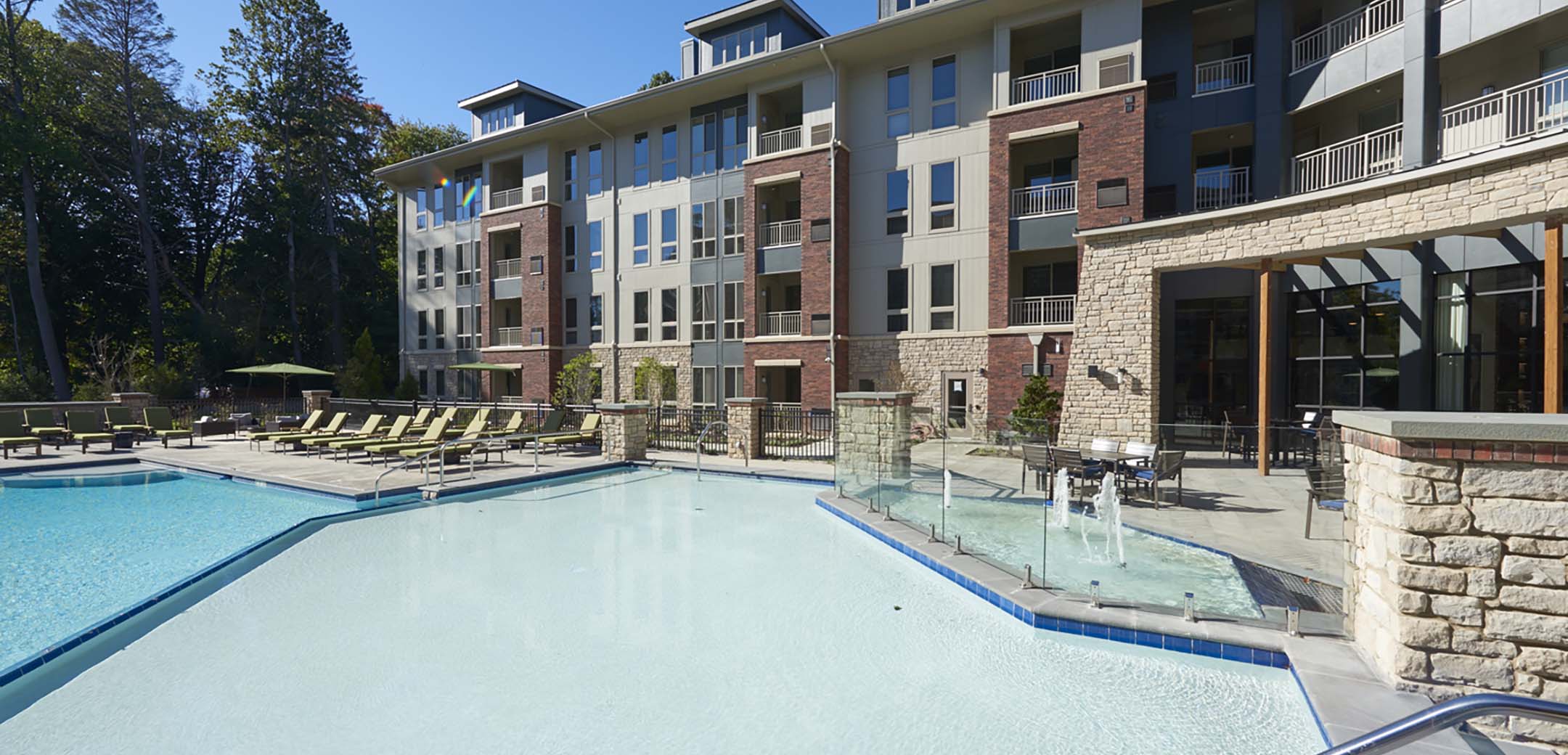 An angled view of the Maybrook inner courtyard showcasing the multi level pool, splashing fountain and large sun bathing area.