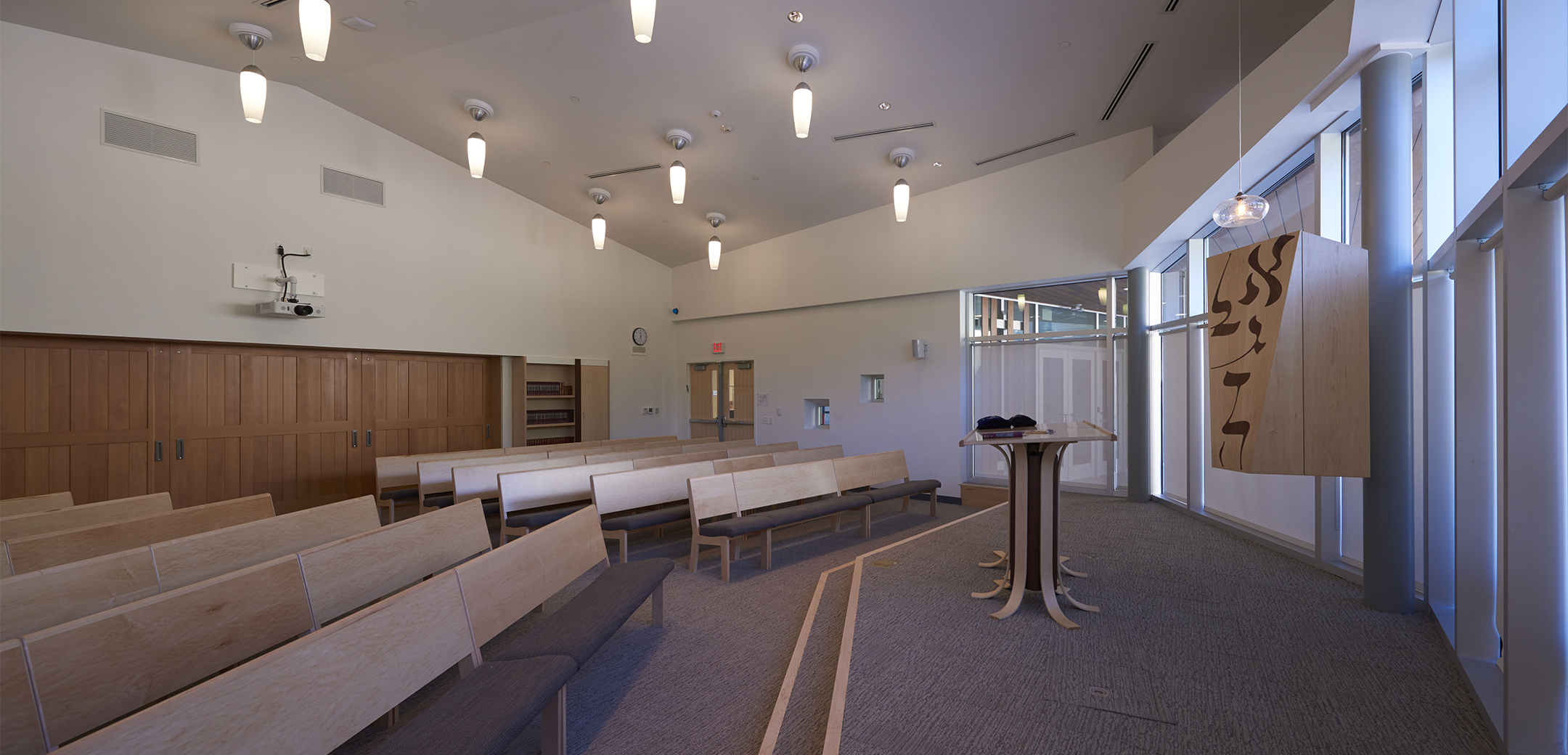 An interior view of the Gottesman RTW Academy showcasing a large open space with a speaking podium and two six rows of seating.