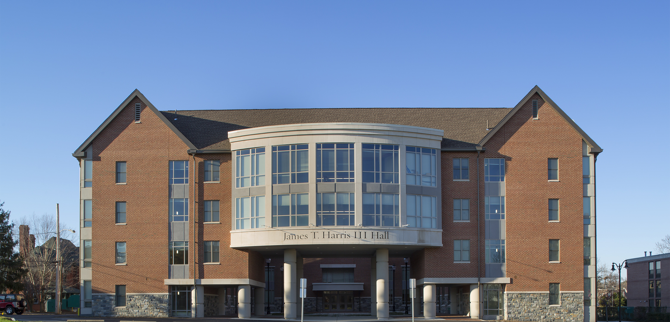 The exterior of Widener University building from the front showcasing the overhang tunnel arc leading to the inner courtyard.