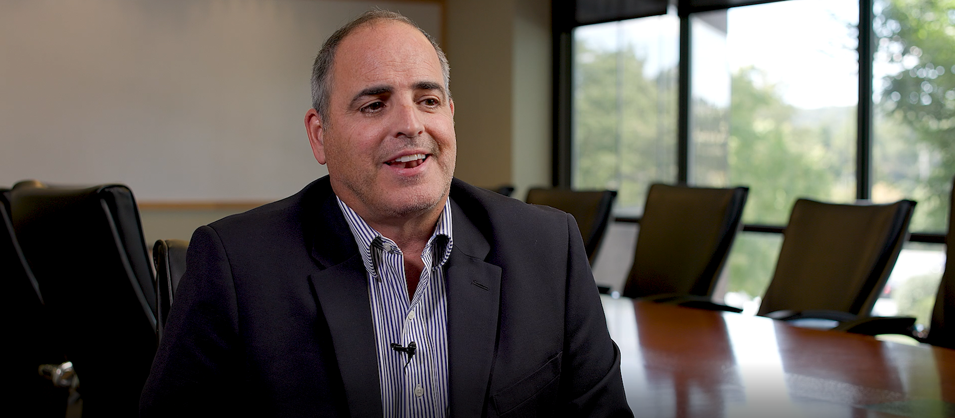 A still shot of Barry Henry, VP of Trammell Crow Company in a suit and tie with a conference room in the background
