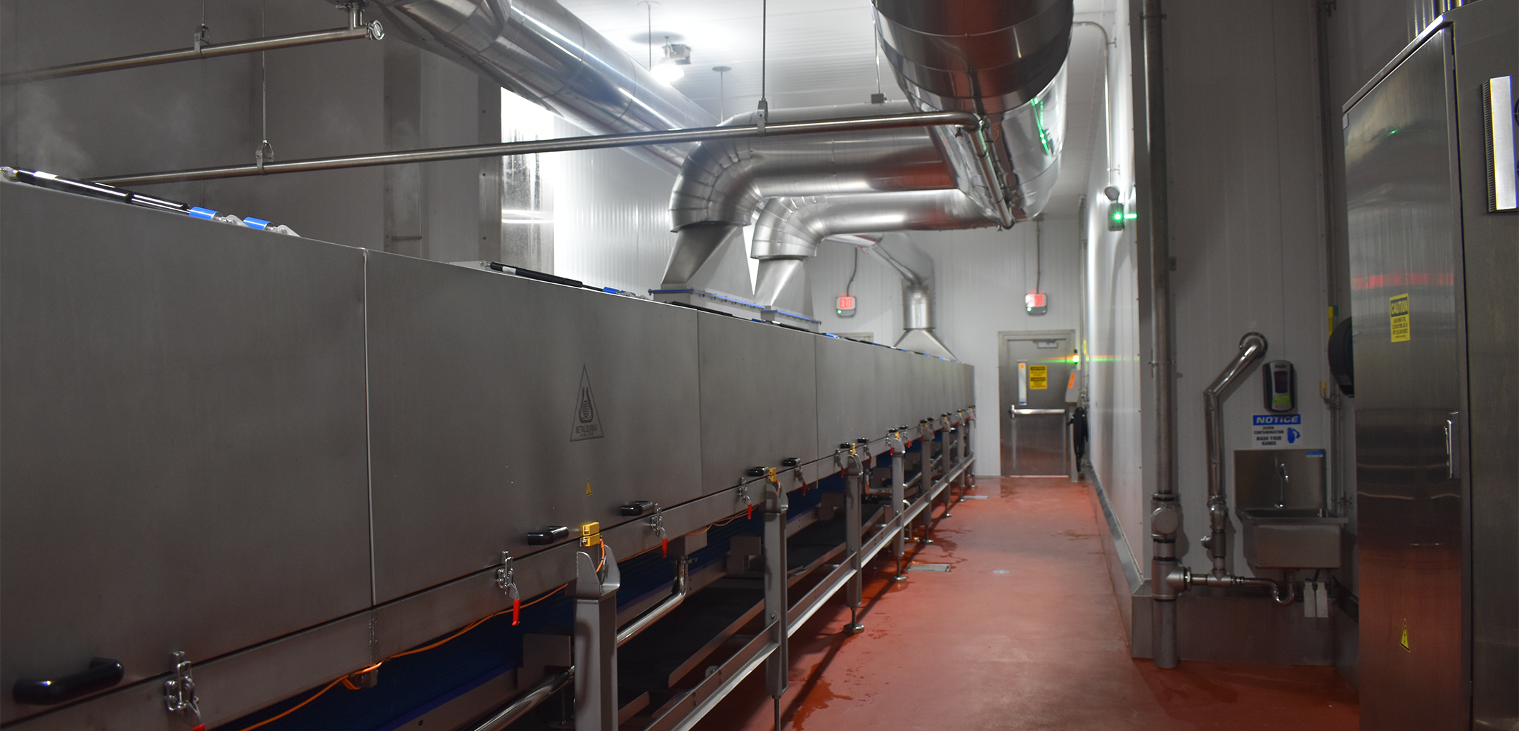 The interior of an industrial plant with a long metal machine.
