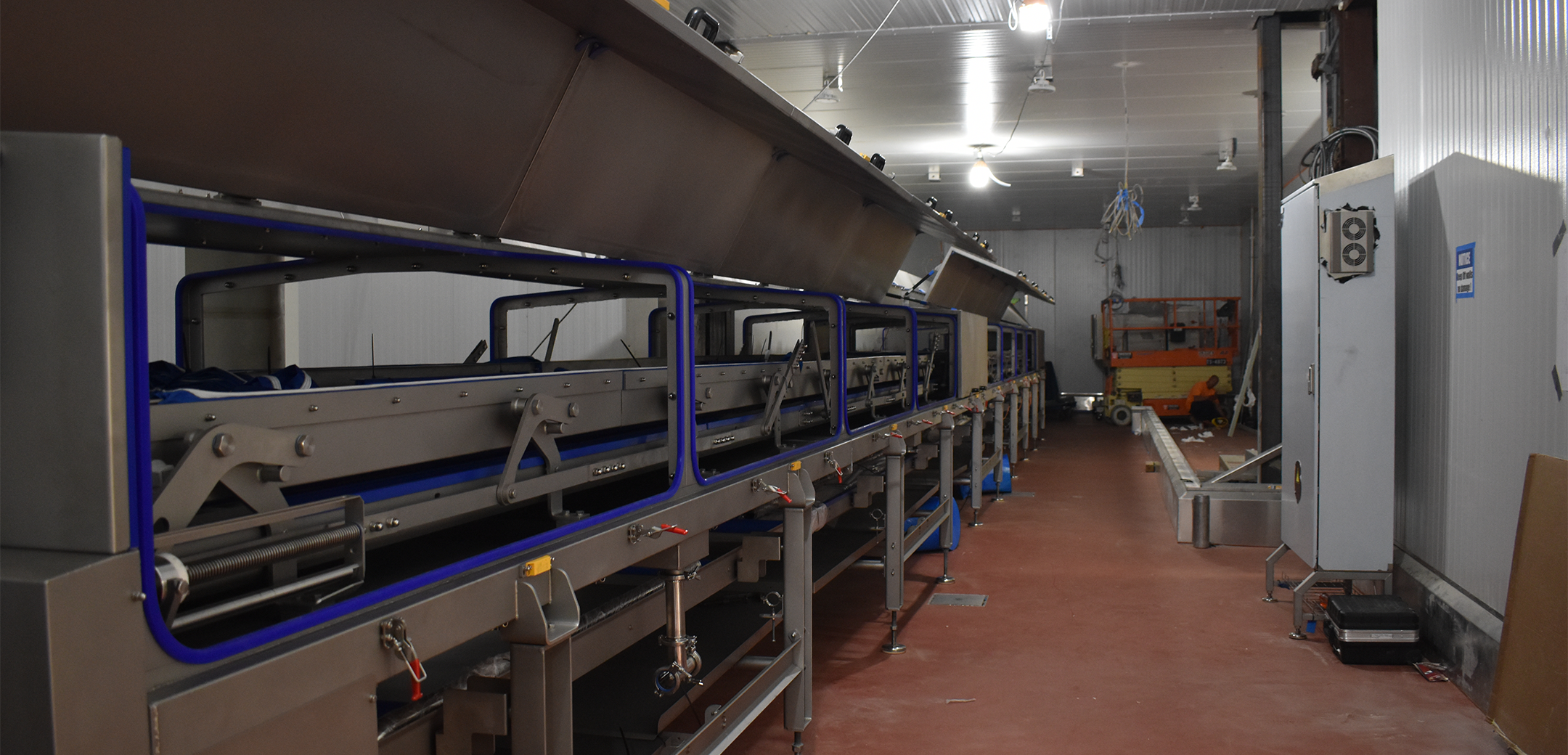 The interior of an industrial plant with a long metal machine.
