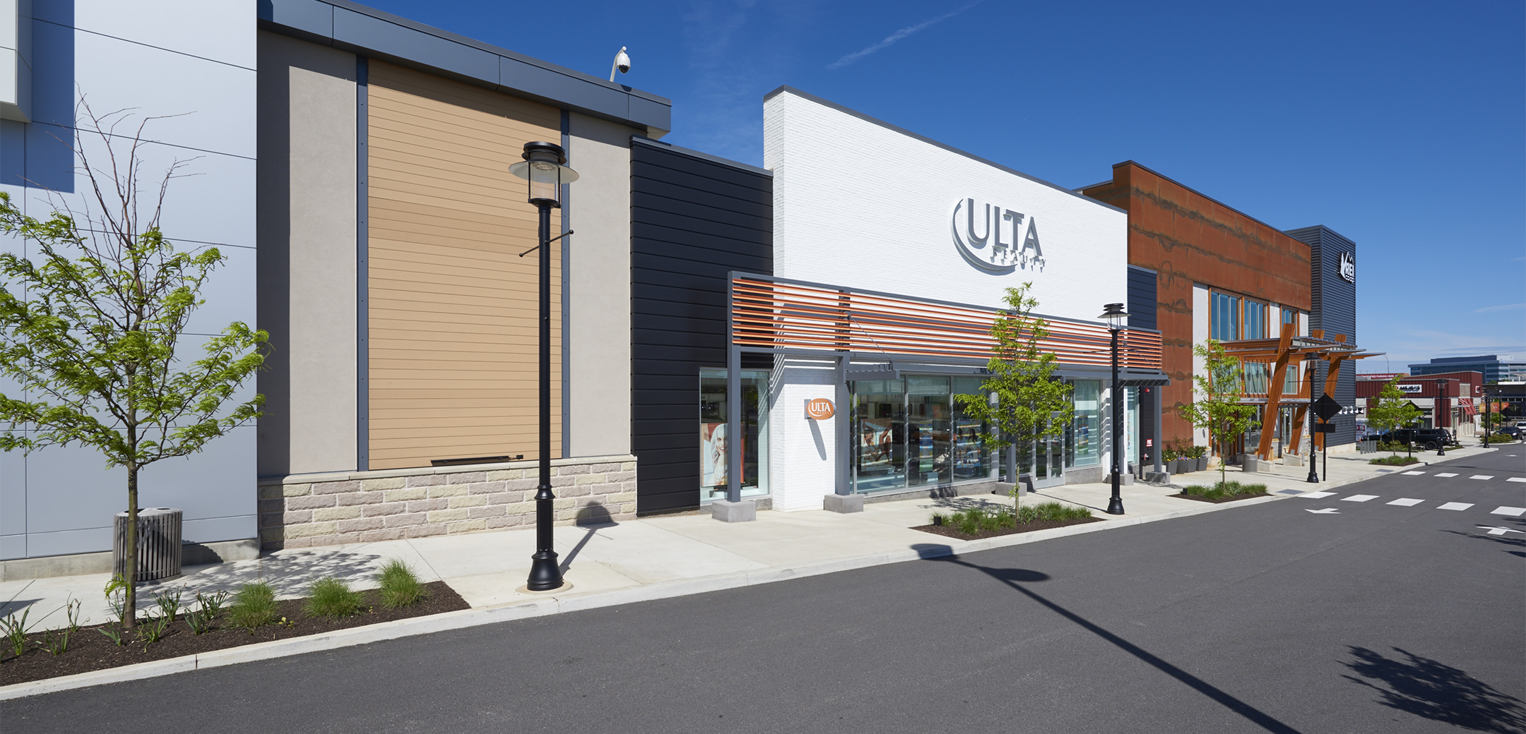 An angled view of the KOP Center storefront strip, showcasing the wooden accents, sidewalk and front street.