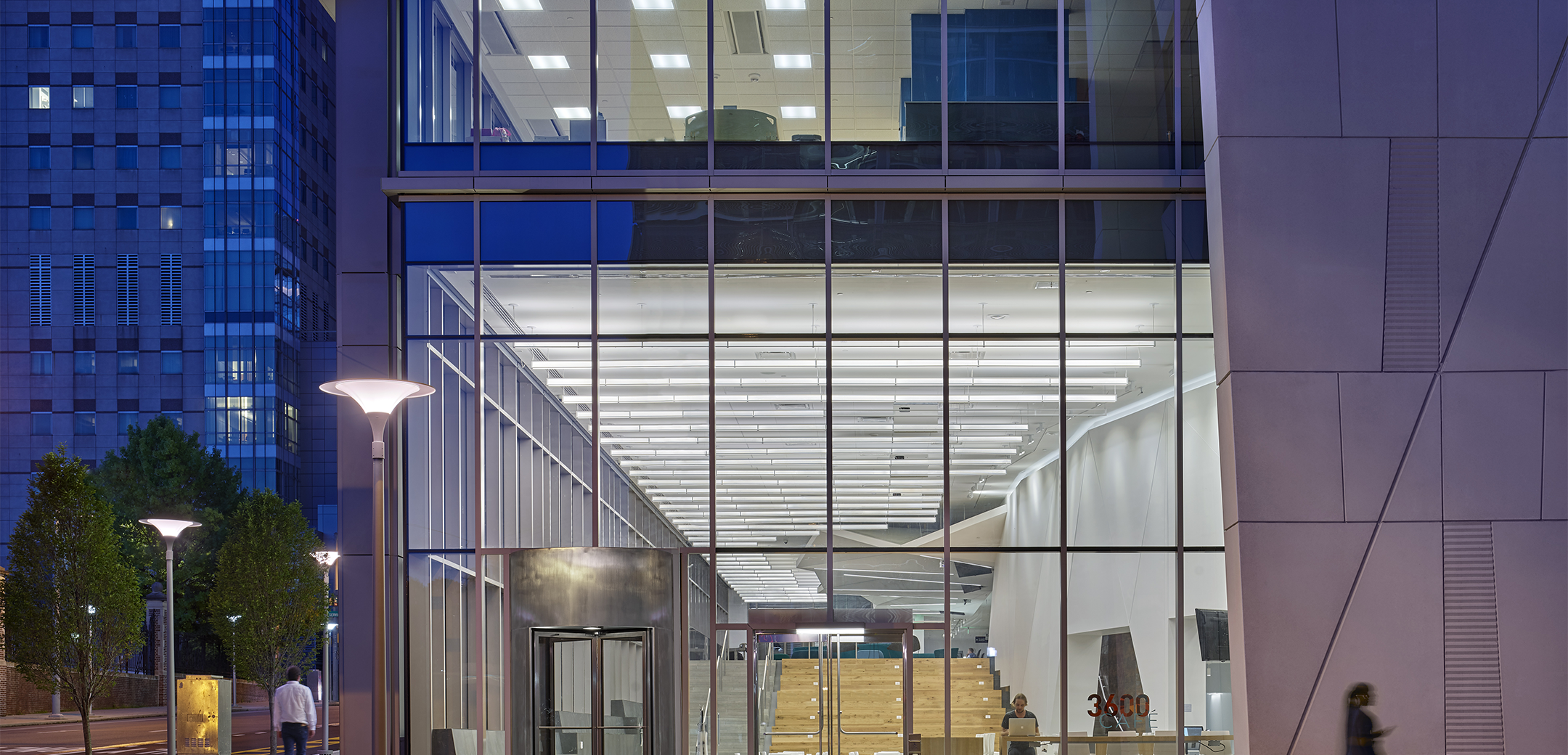 A nightime close up of Penn Medicine Center of Technology's lobby taken from the street outside.