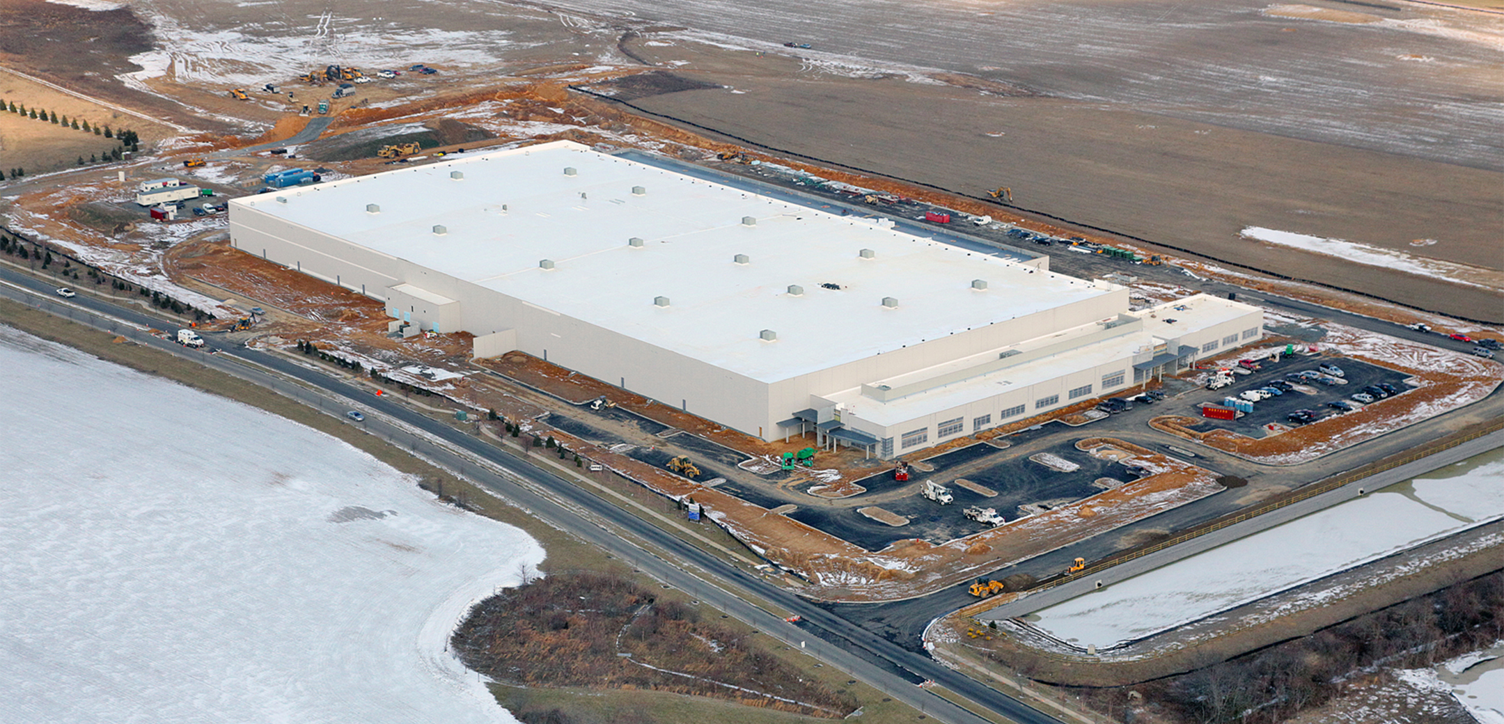 An aerial view of the Project Liberty Distribution buildings showcasing layout, parking space, main road and open field.