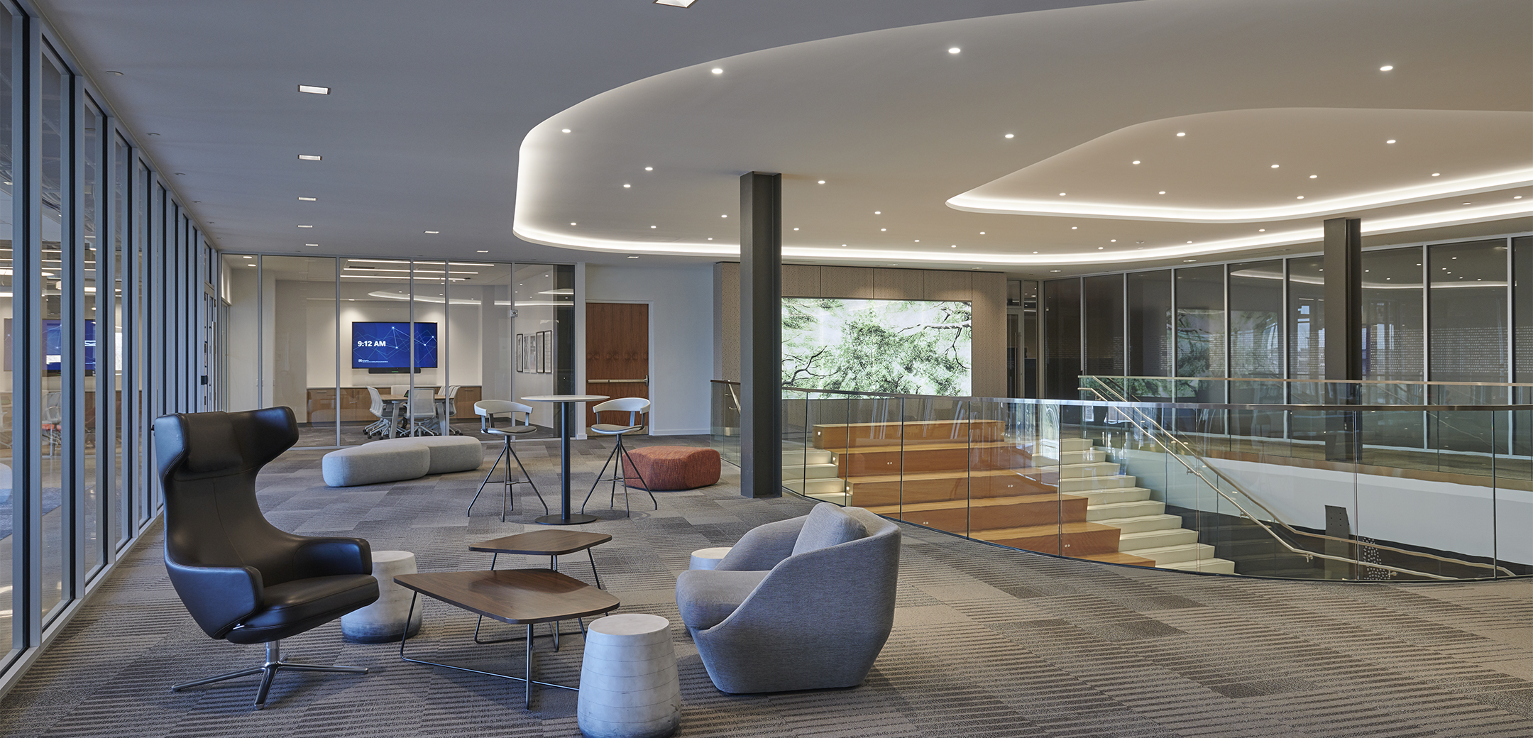 The second floor of Signant Health Headquarters featuring office furniture, conference rooms, and the wide communication stair in the background.